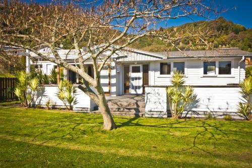 a white house with a tree in the yard at 3 & 4 Bedroom Holiday Houses Central Picton in Picton