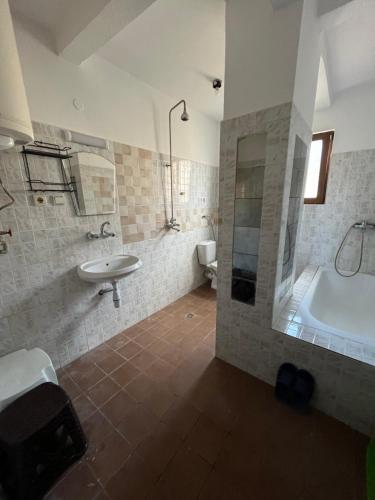 a bathroom with a sink and a tub and a toilet at Grande Apartment in Tsarevo