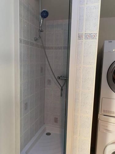 une salle de bains pourvue d'une douche et d'un lave-linge. dans l'établissement La Parencelle proche Boulerie Jump, PEC, Circuit, à Yvré-lʼÉvêque