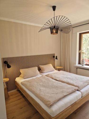 Un dormitorio con una cama grande y una lámpara de araña. en Haus Daut, en Willingen