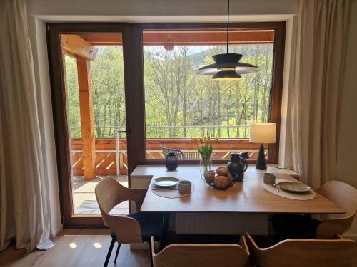 a dining room with a table and a large window at Haus Daut in Willingen