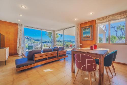 sala de estar con sofá y mesa con sillas en Casa William - Villa e 2 Dependance, en Porto Azzurro