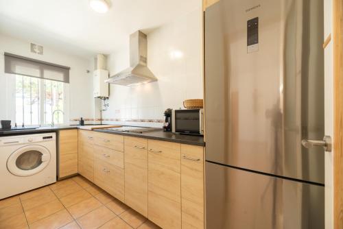 een keuken met een koelkast en een wasmachine bij Apartamento Playa La Barrosa in Chiclana de la Frontera