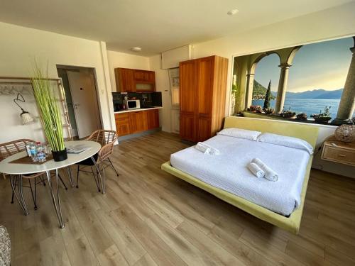 a bedroom with a bed and a table and a kitchen at VARENNA GUEST HOUSE 2 in Varenna