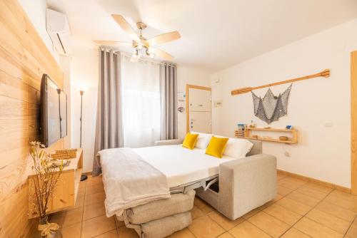 a bedroom with a bed with yellow pillows at Apartamento Playa La Barrosa in Chiclana de la Frontera