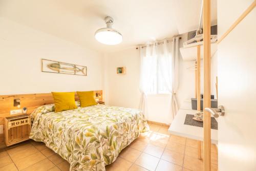ein Schlafzimmer mit einem Bett mit gelben Kissen in der Unterkunft Apartamento Playa La Barrosa in Chiclana de la Frontera