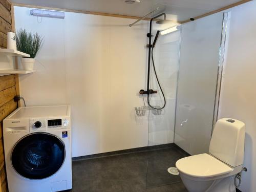 łazienka z pralką i toaletą w obiekcie Leirvåg w mieście Bukta