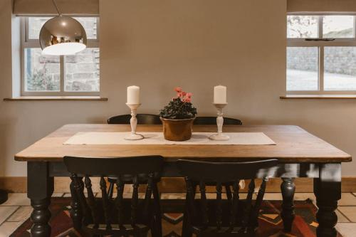 a dining room table with three candles and a potted plant at Cosy Cottage near Brimham Rocks Yorkshire Dales in Grantley