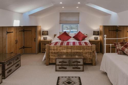 a bedroom with a large bed with red pillows at Cosy Cottage near Brimham Rocks Yorkshire Dales in Grantley