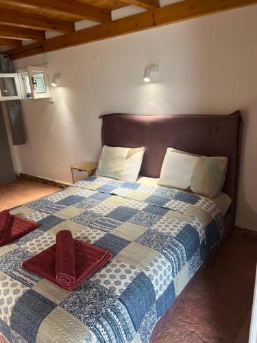 a bedroom with a bed with a blue and white quilt at Hamre Apartments (Nicholas) in Agios Georgios Pagon