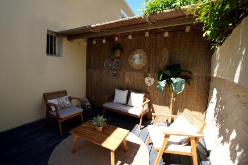 un patio con sedie, divano e tavolo di La paillotte - Studio terrasse proche tram a Montpellier