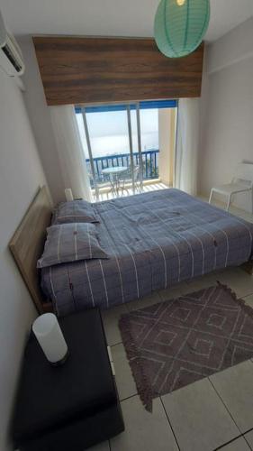 a bedroom with a bed and a large window at Peaceful Beach Location in Limassol