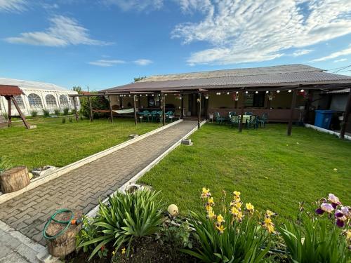 a house with a patio and a yard with flowers at Gigios Sport&Relax in Băileşti