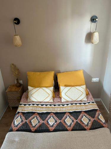 um quarto com uma cama com duas almofadas em Studio H&M: chic*10 mins Disney*30 mins Paris*wifi em Bussy-Saint-Georges