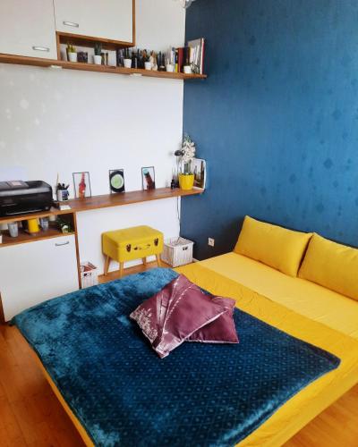 un salon avec un canapé et un mur bleu dans l'établissement Lyon Fête des Lumières, Séjournez près du Parc de la Tête d'Or, à Villeurbanne