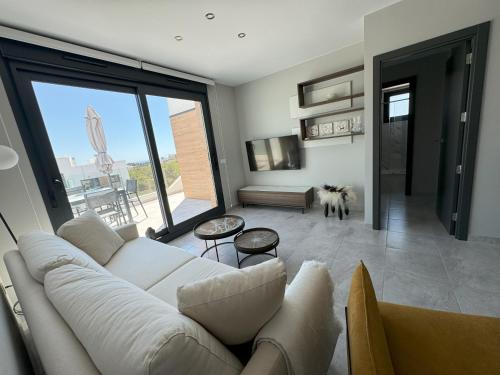 a living room with a white couch and a large window at The Aire Residencial by Mar Holidays in Orihuela
