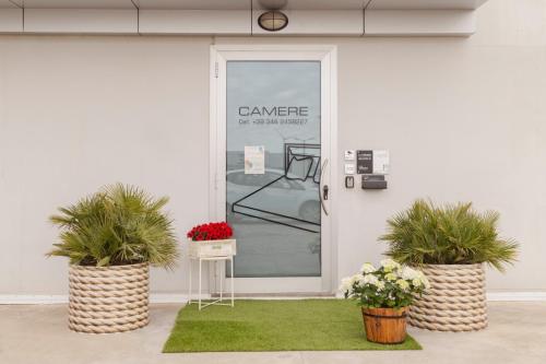 a white door with two potted plants in front of it at Il Chiesino in Pontedera