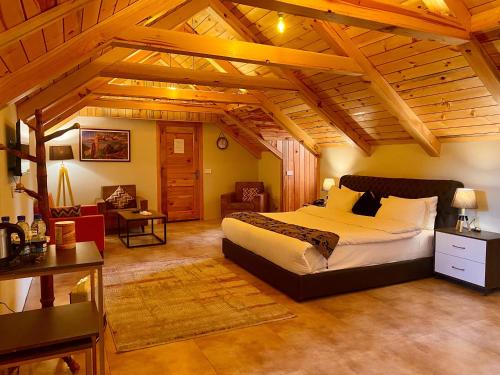 a bedroom with a large bed in a room with wooden ceilings at Fogland Hotel Nathia Gali in Nathia Gali