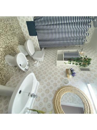 een badkamer met 2 toiletten, een wastafel en een spiegel bij Apartamento familiar a 200m de la playa in Alcossebre