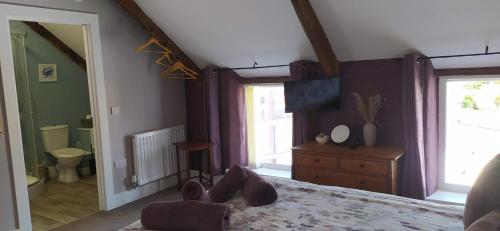 een persoon die op een bed in een slaapkamer ligt bij Gorgeous dog friendly cottage in Kidwelly