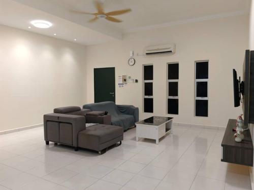 a living room with two couches and a ceiling fan at Homestay Sitiawan 53 in Sitiawan