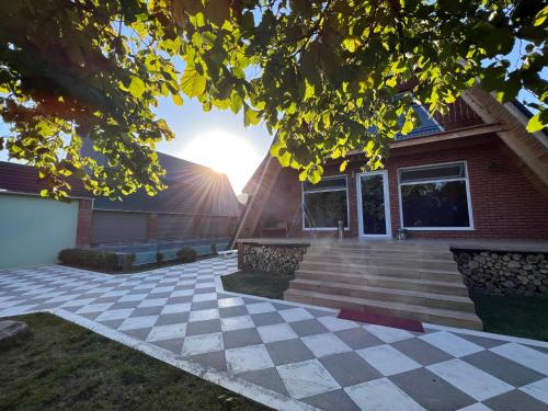 a house with a checkered floor in front at Qafqaz Suite Paradise Chalet & SPA in Gabala