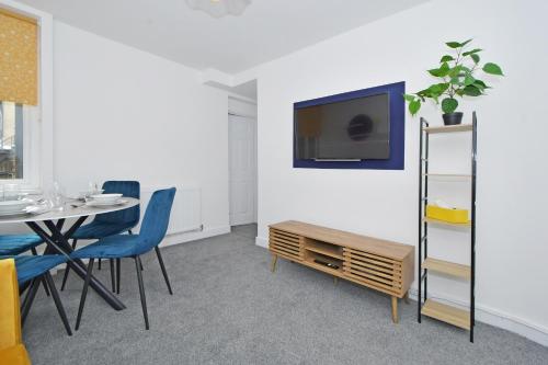 a dining room with a table and a tv on a wall at Sapphire Apartments by YourStays - Luxury 2 Bedroom Apartments in Crewe in Crewe
