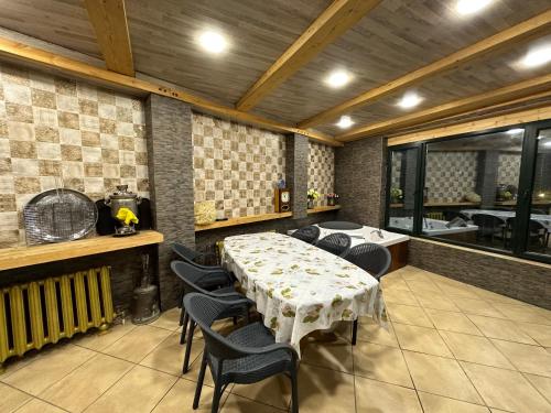 a room with a table and chairs and a kitchen at Qafqaz Suite Paradise Chalet & SPA in Gabala