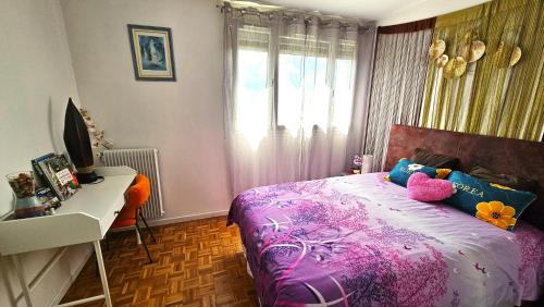 a bedroom with a bed and a desk and a window at Appartement avec balcon proche Paris & Disneyland in Champigny-sur-Marne