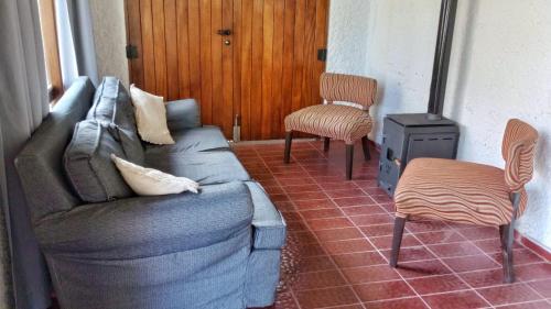 a living room with a couch and two chairs at El Torreón Lodge in Potrerillos