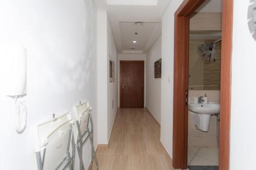 a hallway with a bathroom with a sink and a mirror at Fully Furnished Studio In JVC RL in Dubai