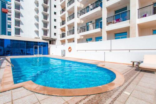 a swimming pool in front of a building at Fully Furnished Studio In JVC RL in Dubai