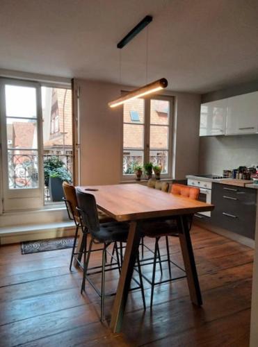 une cuisine avec une table en bois et quelques chaises dans l'établissement Appartement plein centre avec vue exceptionnelle cathédrale, à Strasbourg