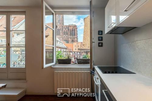 une cuisine avec vue sur la ville depuis une fenêtre dans l'établissement Appartement plein centre avec vue exceptionnelle cathédrale, à Strasbourg