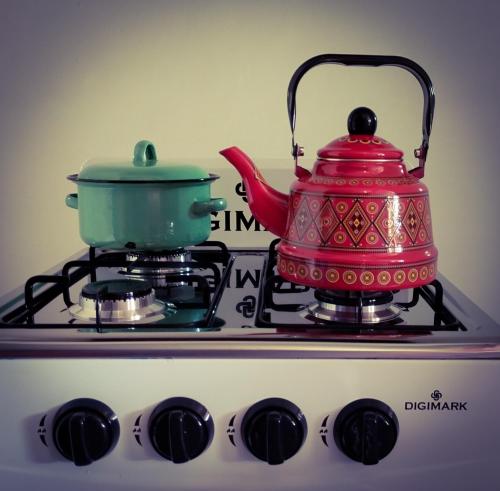 a red teapot sitting on top of a stove at Romantic Vintage Cottage, Views across vineyards. in Currieʼs Camp
