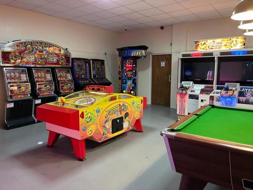 een speelkamer met een pooltafel en speelautomaten bij All Seasons Chalet Breaks in Leysdown-on-Sea