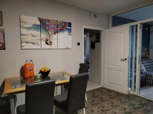een eetkamer met een tafel en stoelen en een deur bij Weekend varijanta Plus in Novi Sad