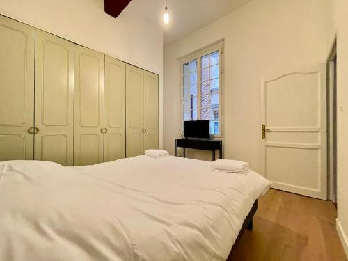 une chambre avec un grand lit blanc et une fenêtre dans l'établissement Paradoux by Yumē, à Toulouse