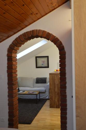 einen Torbogen, der in ein Wohnzimmer mit einem Sofa führt in der Unterkunft UrbanStudio5 in Čakovec