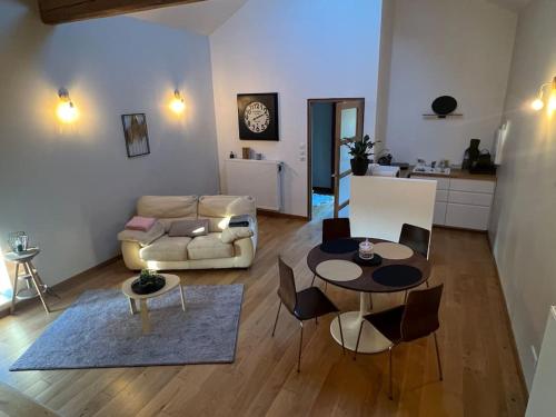 un salon avec un canapé, une table et des chaises dans l'établissement 5 mn Vienne, confort et calme à la campagne, à Reventin-Vaugris