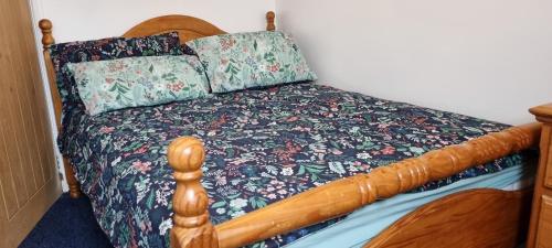 a bedroom with a bed with a floral bedspread at Smart Large Room with disabled facilities Idealy Located near Doncaster - Rotherham -Sheffield in Rotherham