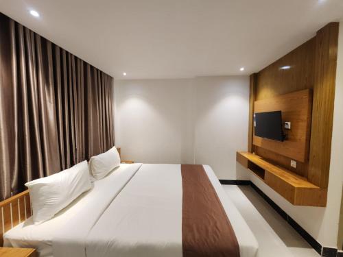 1 dormitorio con 1 cama grande y TV en Sea Paradise en Cox's Bazar