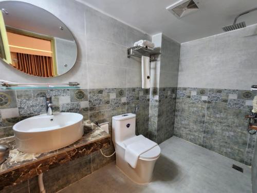 La salle de bains est pourvue d'un lavabo, de toilettes et d'un miroir. dans l'établissement Sea Paradise, à Cox's Bazar