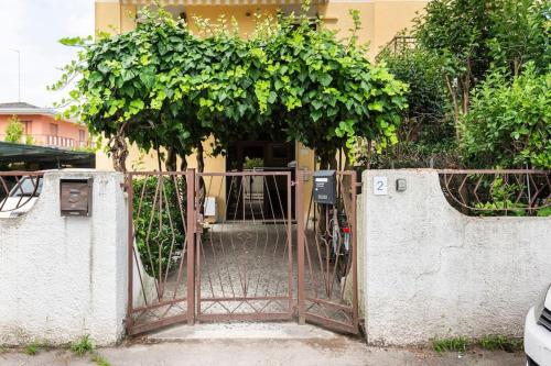 an open gate to a building with a tree at 200m from the sea, beach place included in Lido di Jesolo