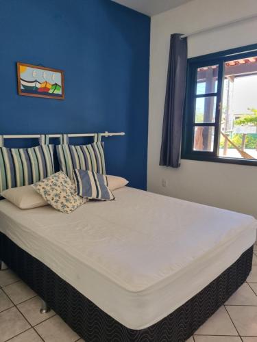 een slaapkamer met een groot bed met een blauwe muur bij Canto das Ondas Apart Studios in São Francisco do Sul