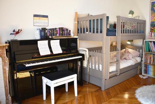 une chambre de bébé avec un piano et un lit superposé dans l'établissement Montmartre, à Paris