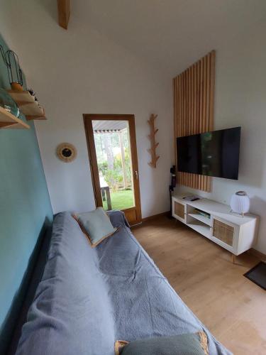 un salon avec un lit et une télévision dans l'établissement La_pinede_lacanau_ocean, à Lacanau-Océan