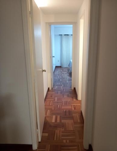 a hallway with a long corridor with wooden floors at Cómodo apartamento céntrico con garaje in Montevideo