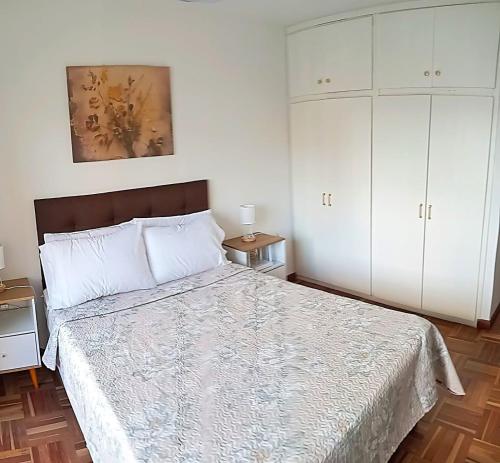 a bedroom with a bed and white cabinets at Cómodo apartamento céntrico con garaje in Montevideo