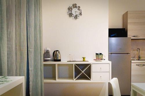 a kitchen with a table and a refrigerator at Sunrise Luxury Apartments in Cassibile
